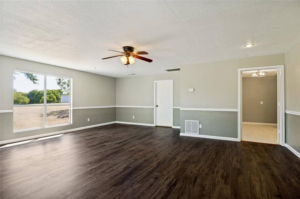 2406 County Road 852, McKinney, TX 75071 Spacious room featuring wood-finish flooring, a ceiling fan with integrated lighting, recessed lighting, and a large picture window