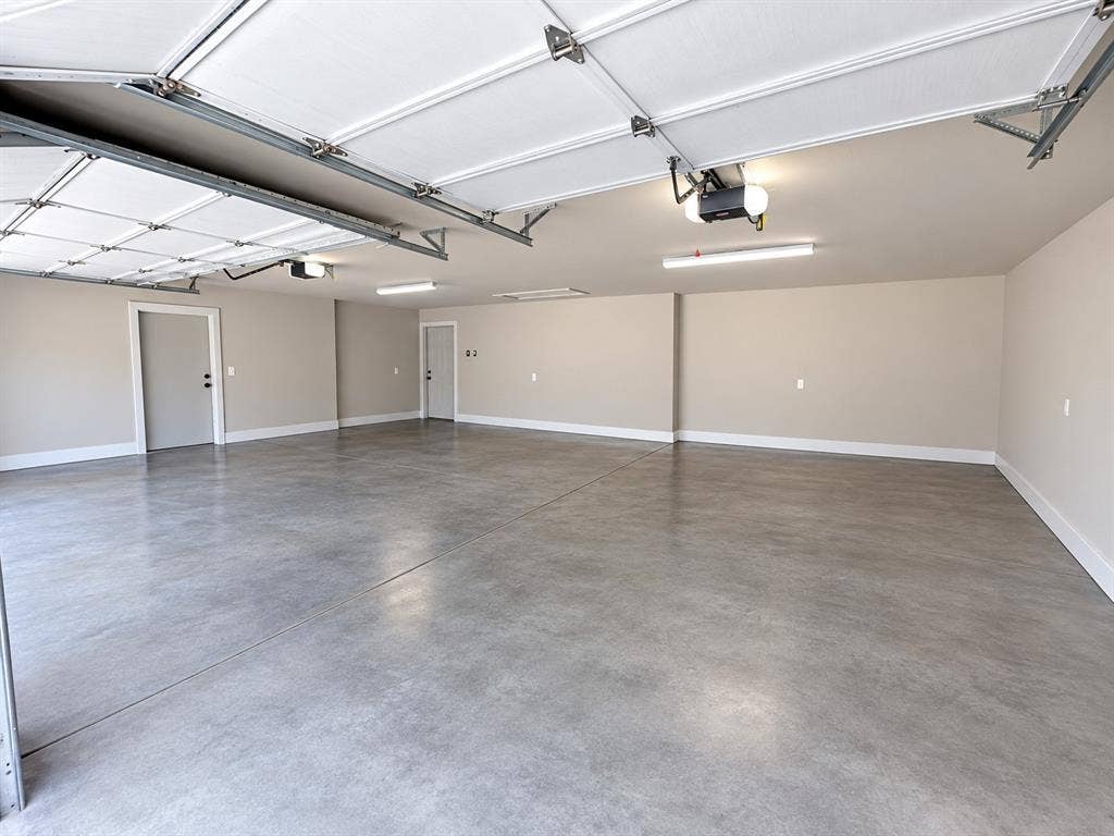 2406 County Road 852, McKinney, TX 75071 Spacious garage with light grey painted walls and a smooth concrete floor