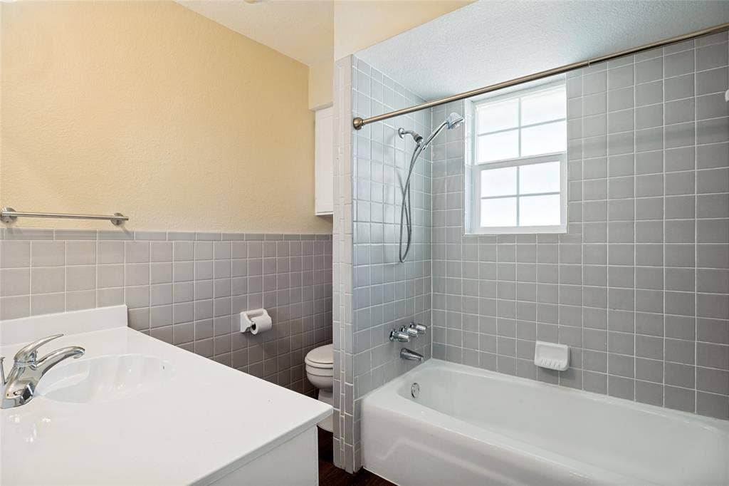 2406 County Road 852, McKinney, TX 75071 Bathroom featuring a single vanity, tiled shower-tub combination, and a window for natural light
