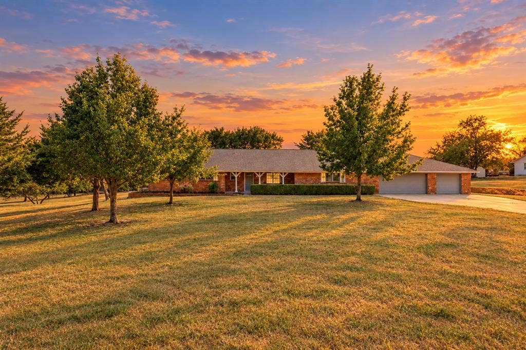 2406 County Road 852, McKinney, TX 75071 Brick exterior with a covered porch, attached two-car garage, and mature trees
