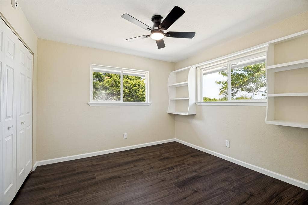 2406 County Road 852, McKinney, TX 75071 Wood-finish flooring, two large windows, built-in shelving, ceiling fan with light, and bi-fold closet doors