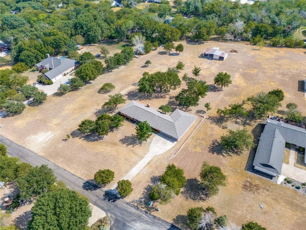 2406 County Road 852, McKinney, TX 75071 Expansive property featuring a single-story residence, a lengthy paved driveway, and mature landscaping