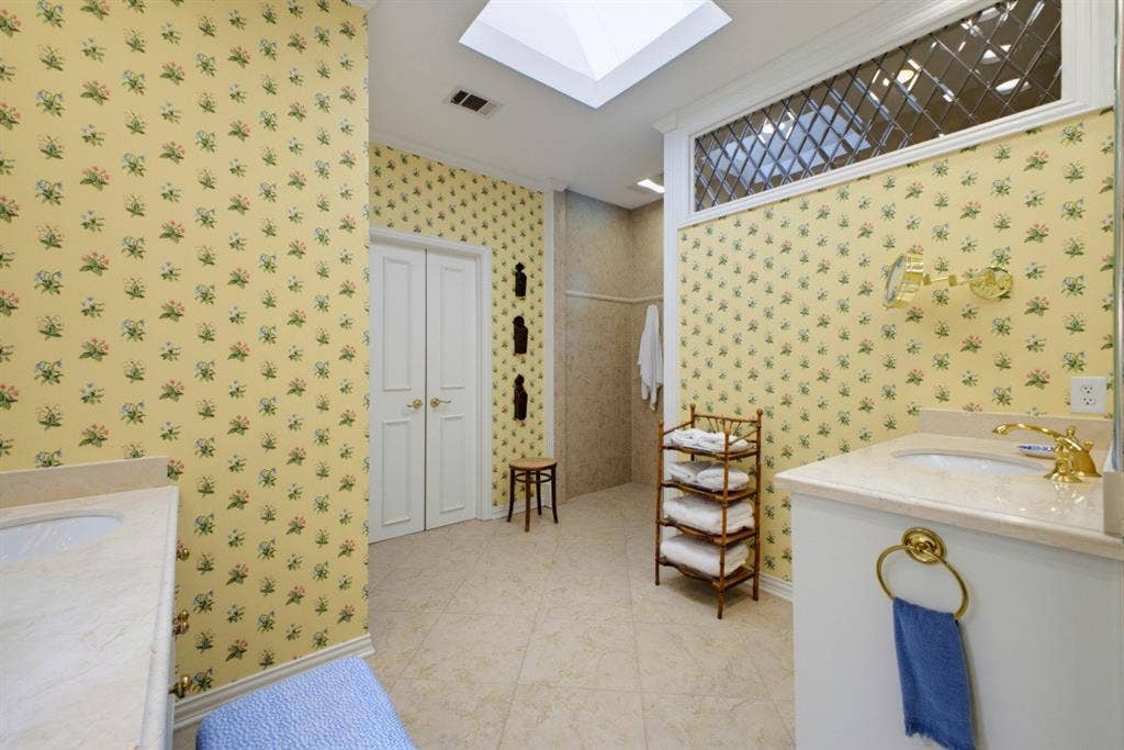 12012 Excelsior Way, Dallas, TX 75230 Dual vanities with integrated sinks, a skylight, tile flooring, and a leaded glass transom window