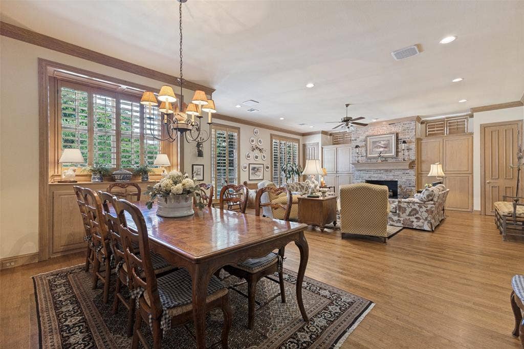 12012 Excelsior Way, Dallas, TX 75230 Wood-finish flooring throughout, custom wood cabinetry, fireplace with stone surround, crown molding, and plantation shutters