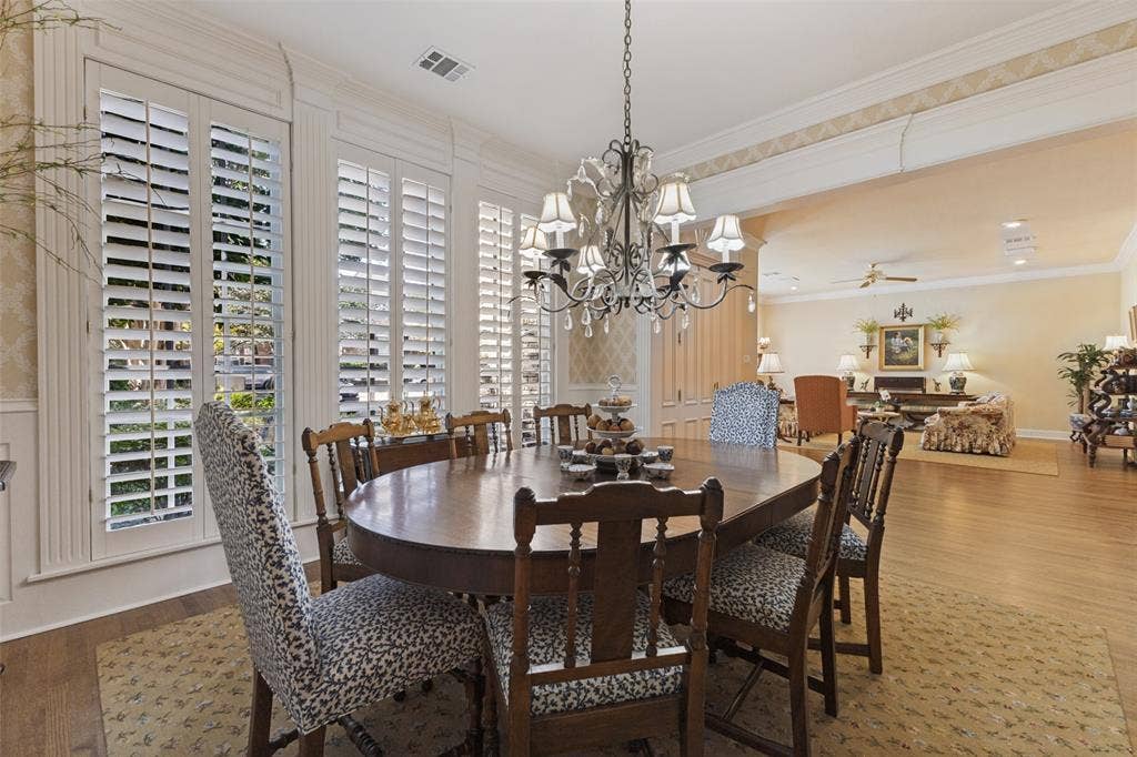 12012 Excelsior Way, Dallas, TX 75230 Expansive dining area featuring a chandelier, wood-finish flooring, and plantation shutters