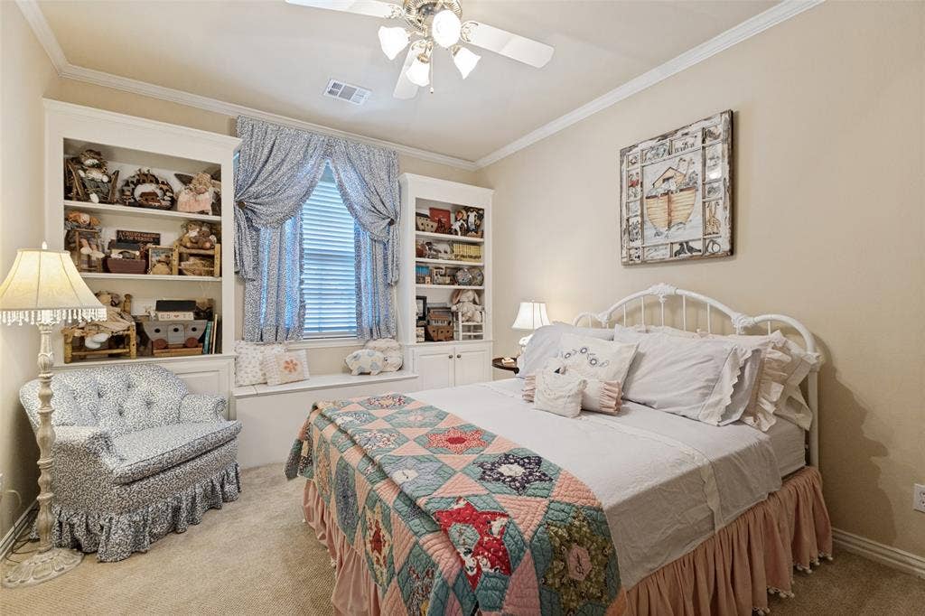 12012 Excelsior Way, Dallas, TX 75230 Built-in shelving flanking a window with a built-in bench, carpet flooring, a ceiling fan, and crown molding