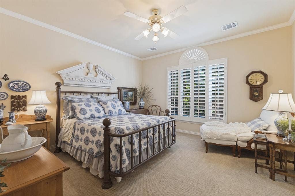 12012 Excelsior Way, Dallas, TX 75230 Carpeted room featuring a ceiling fan, crown molding, and windows with plantation shutters
