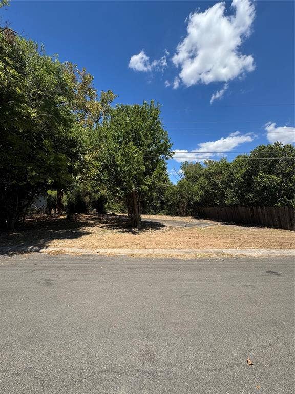 113 Bridle Trail, Hewitt, TX 76643 Expansive lot featuring mature trees, a paved driveway, and a wood privacy fence