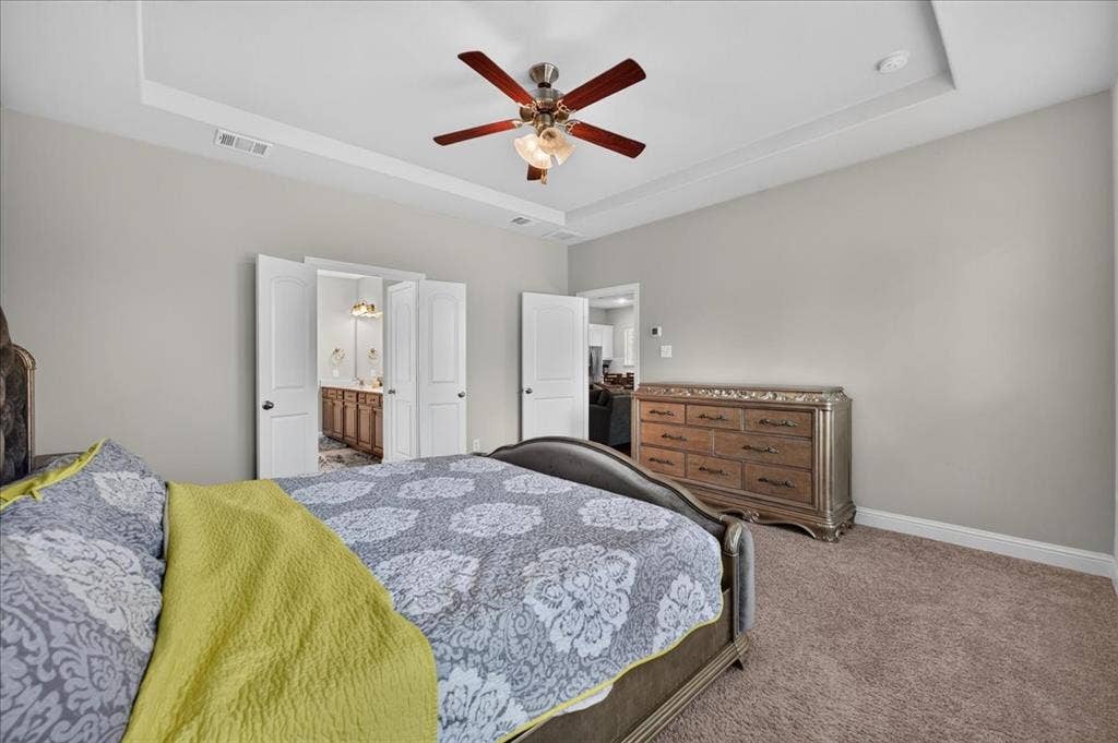 8712 Mccutchins Drive, McKinney, TX 75070 Tray ceiling with a ceiling fan, light gray wall paint, and plush carpeting