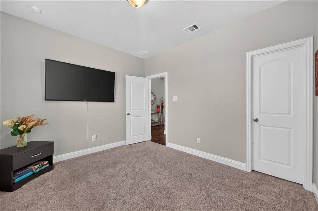 8712 Mccutchins Drive, McKinney, TX 75070 Carpeted flooring, light neutral wall paint, white trim, and a white interior door