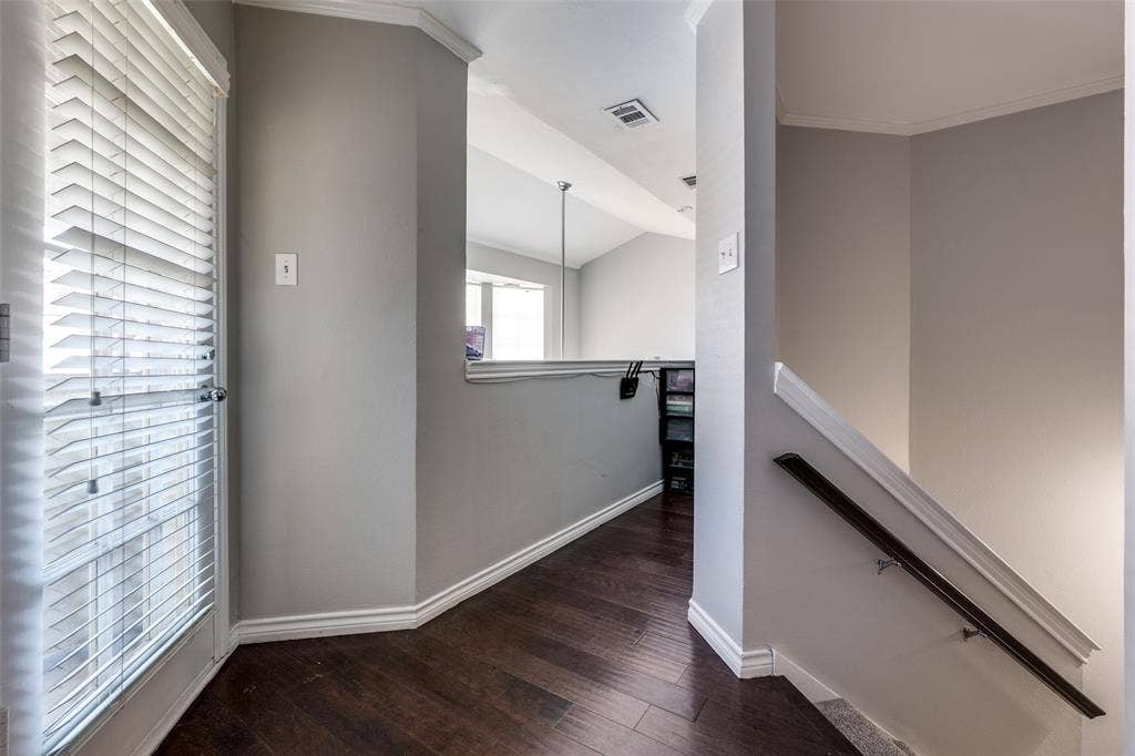 3100 Cole Avenue, #213, Dallas, TX 75204 Hallway featuring an upstairs landing, dark wood finished floors, crown molding, and lofted ceiling