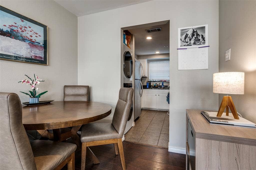 3100 Cole Avenue, #213, Dallas, TX 75204 Dining space with dark wood-style flooring and stacked washer / drying machine