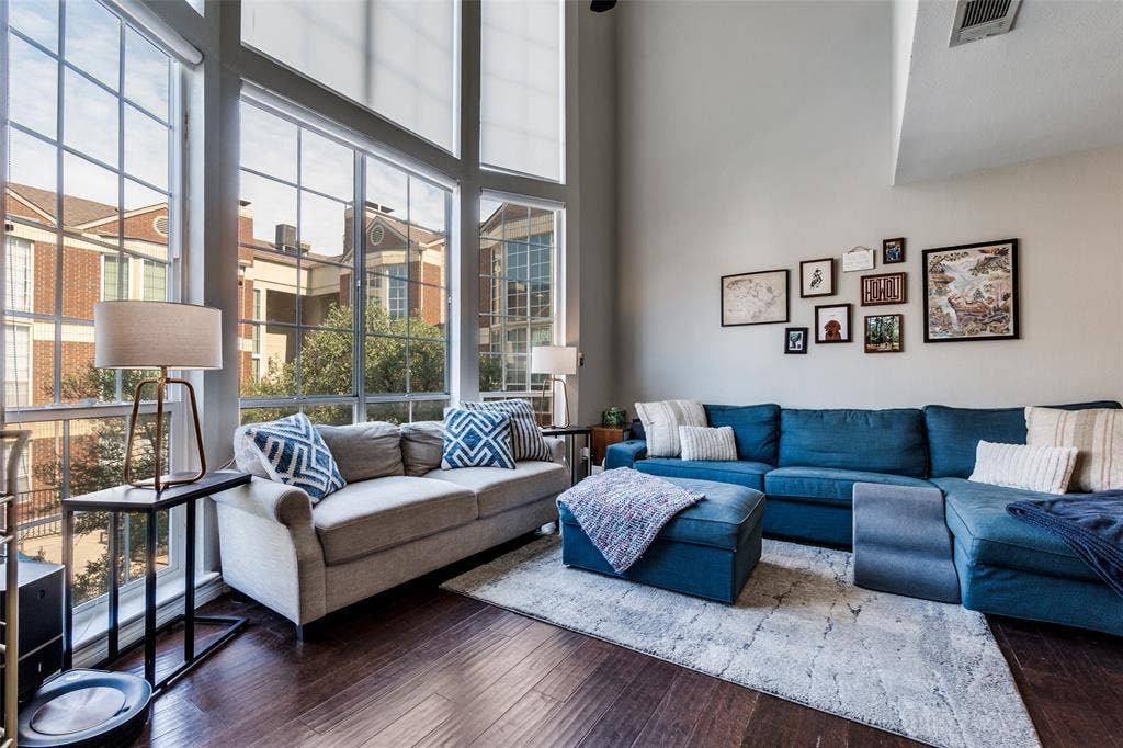 3100 Cole Avenue, #213, Dallas, TX 75204 Living area featuring healthy amount of natural light, hardwood / wood-style floors, and a towering ceiling