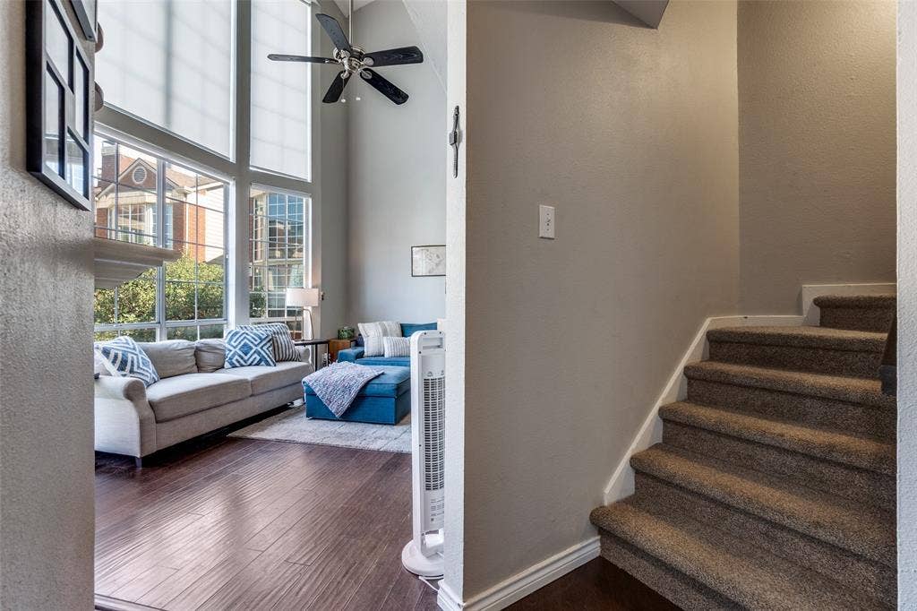3100 Cole Avenue, #213, Dallas, TX 75204 Stairway featuring a ceiling fan, a textured wall, wood finished floors, and a high ceiling