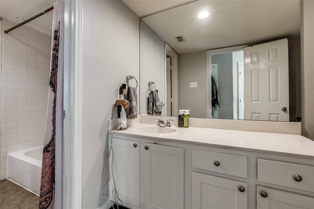 3100 Cole Avenue, #213, Dallas, TX 75204 Bathroom with shower / bath combination with curtain, vanity, and tile patterned flooring