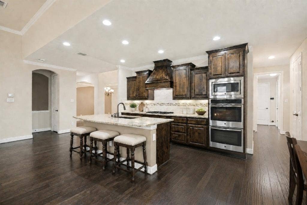 10002 Edgeway Circle, Rowlett, TX 75089 Open kitchen with large island for prep and eating (virtually staged).