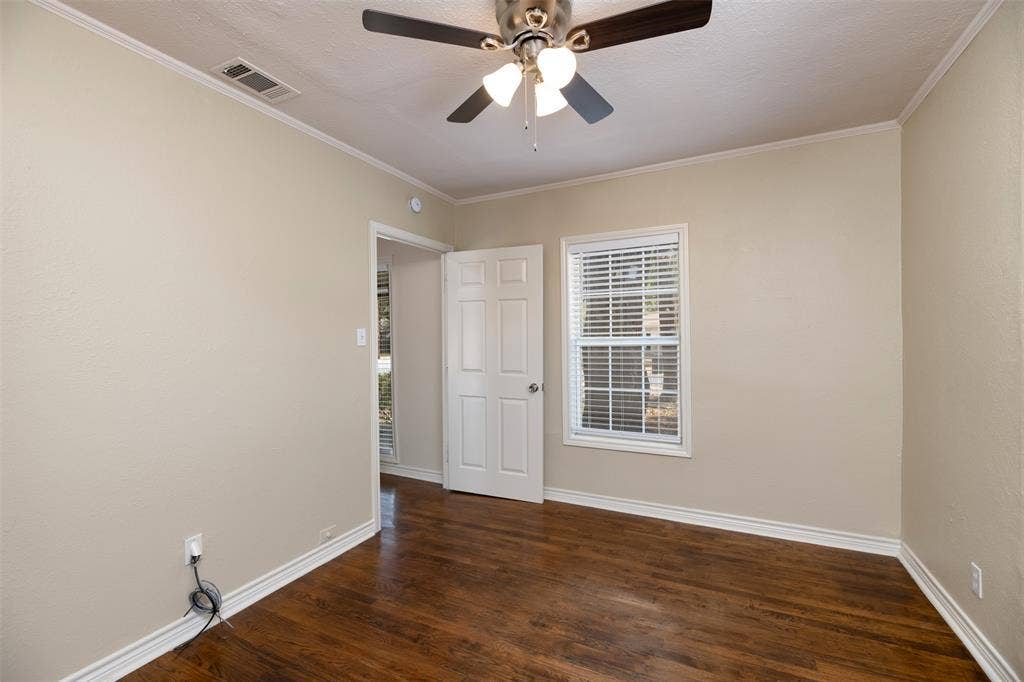 8823 San Benito Way, Dallas, TX 75218 Wood-finish flooring with white trim, a ceiling fan with integrated lighting, a paneled door, and a window with blinds