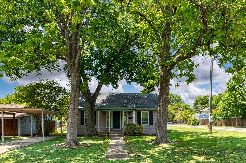 8823 San Benito Way, Dallas, TX 75218 Exterior featuring a gabled roof, light-colored siding, dark shutters, covered entry, and a paved walkway
