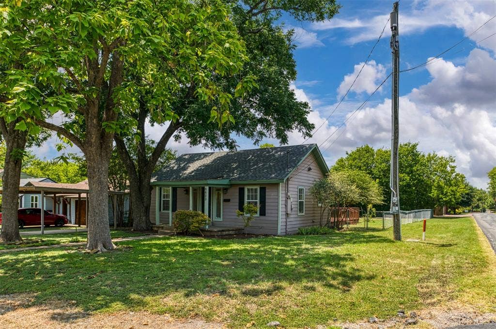 8823 San Benito Way, Dallas, TX 75218 Single-story residence featuring light-colored siding, a covered front porch, and a dark-shingled roof