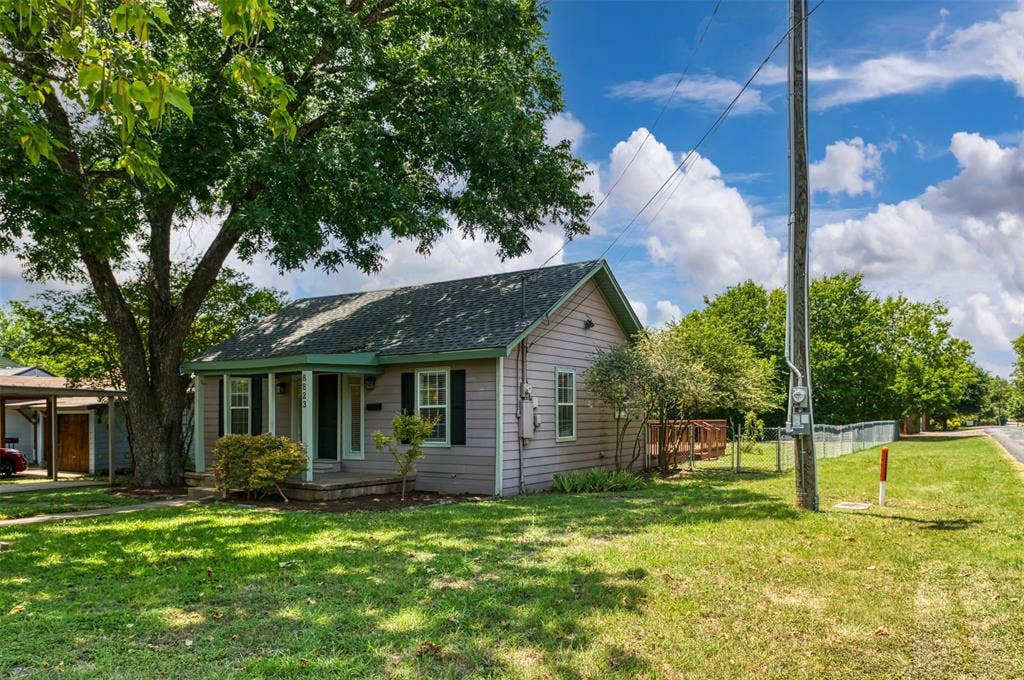 8823 San Benito Way, Dallas, TX 75218 Exterior featuring horizontal siding, a covered porch, a prominent mature tree, and a side wooden deck