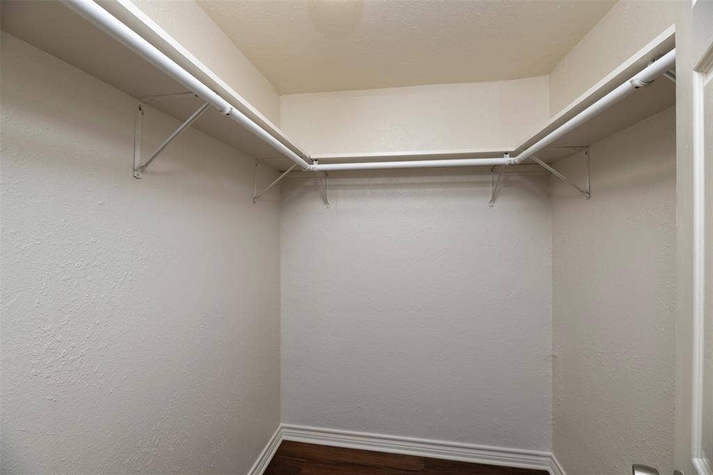 8823 San Benito Way, Dallas, TX 75218 Walk-in closet with white shelving, hanging rods, and wood-finish flooring