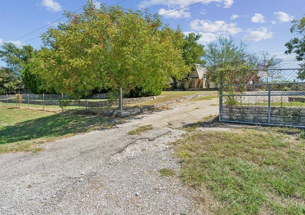 157 Business Boulevard, Granbury, TX 76049 View of road with a gated entry and driveway