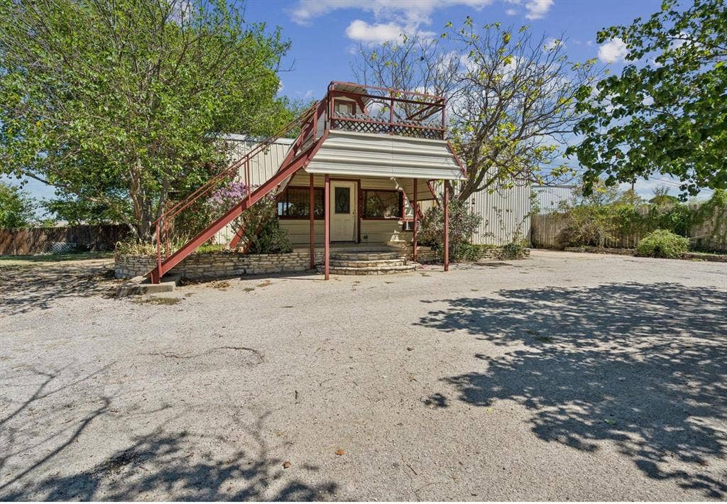 157 Business Boulevard, Granbury, TX 76049 Rear view of house featuring stairs and fence
