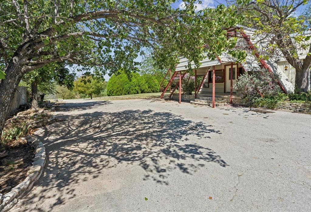 157 Business Boulevard, Granbury, TX 76049 View of yard with covered porch and stairway