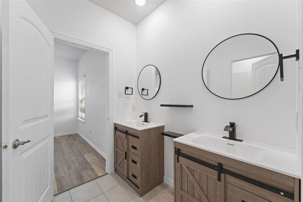 4651 Raleigh Dalton Road, Dallas, TX 75227 Dual vanity with wood-finish cabinetry and matte black hardware