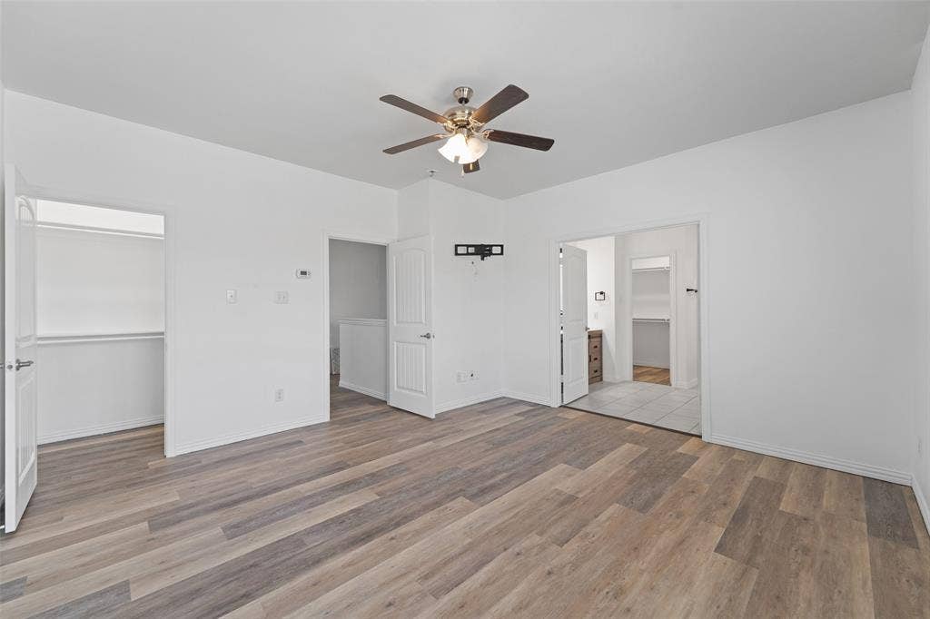 4651 Raleigh Dalton Road, Dallas, TX 75227 Wood-finish flooring, ceiling fan, white walls, and built-in closet shelving