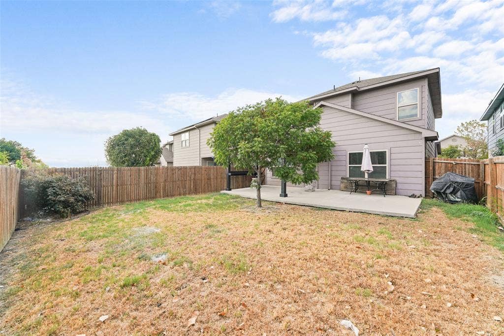 4651 Raleigh Dalton Road, Dallas, TX 75227 Fenced backyard featuring a concrete patio, mature tree, and privacy fencing