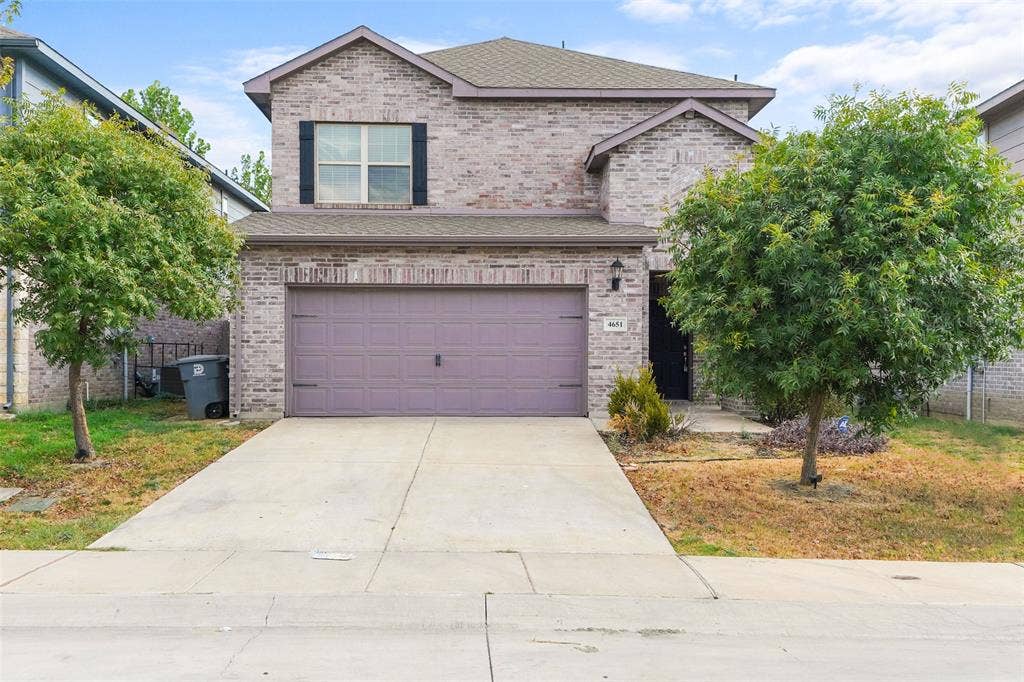 4651 Raleigh Dalton Road, Dallas, TX 75227 Brick exterior featuring a two-car garage, concrete driveway, and front entryway