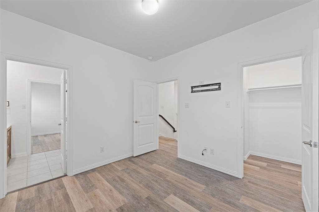 4651 Raleigh Dalton Road, Dallas, TX 75227 Wood-finish flooring with crisp white walls and ceiling