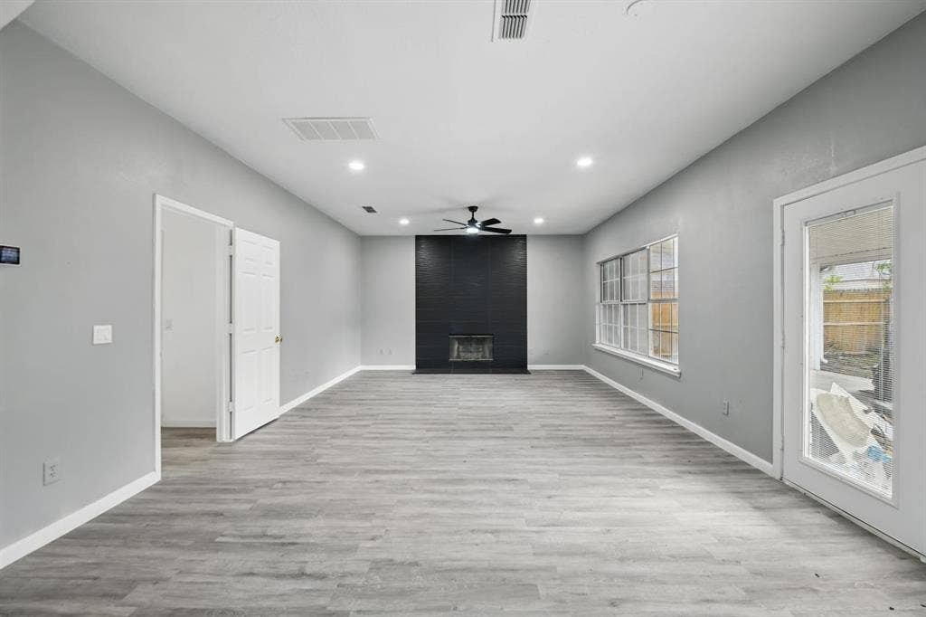 6833 Lyndale Drive, Watauga, TX 76148 Unfurnished living room featuring recessed lighting, a ceiling fan, a fireplace, and wood finished floors