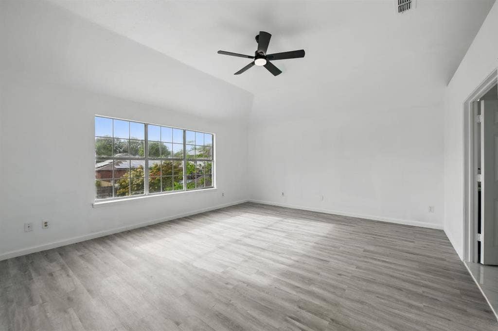 6833 Lyndale Drive, Watauga, TX 76148 Spare room with ceiling fan, wood finished floors, and high vaulted ceiling