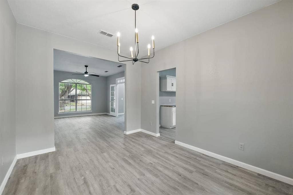 6833 Lyndale Drive, Watauga, TX 76148 Spare room with a chandelier, wood finished floors, and ceiling fan