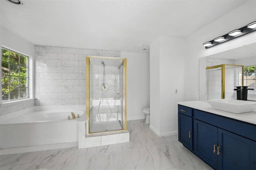6833 Lyndale Drive, Watauga, TX 76148 Bathroom with vanity, a stall shower, a bath, and marble look tile flooring