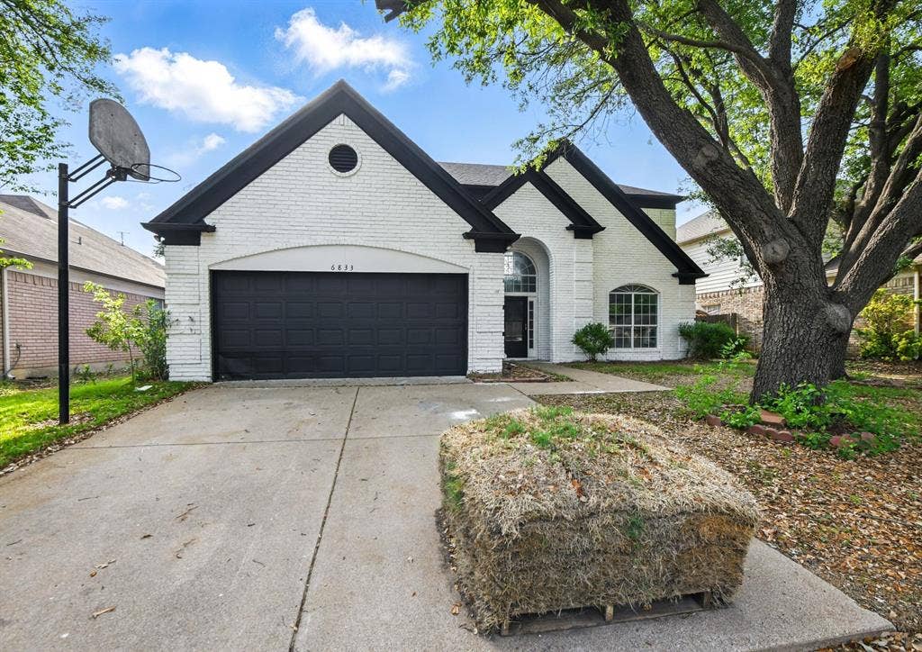 6833 Lyndale Drive, Watauga, TX 76148 View of front of property with brick siding, an attached garage, and driveway