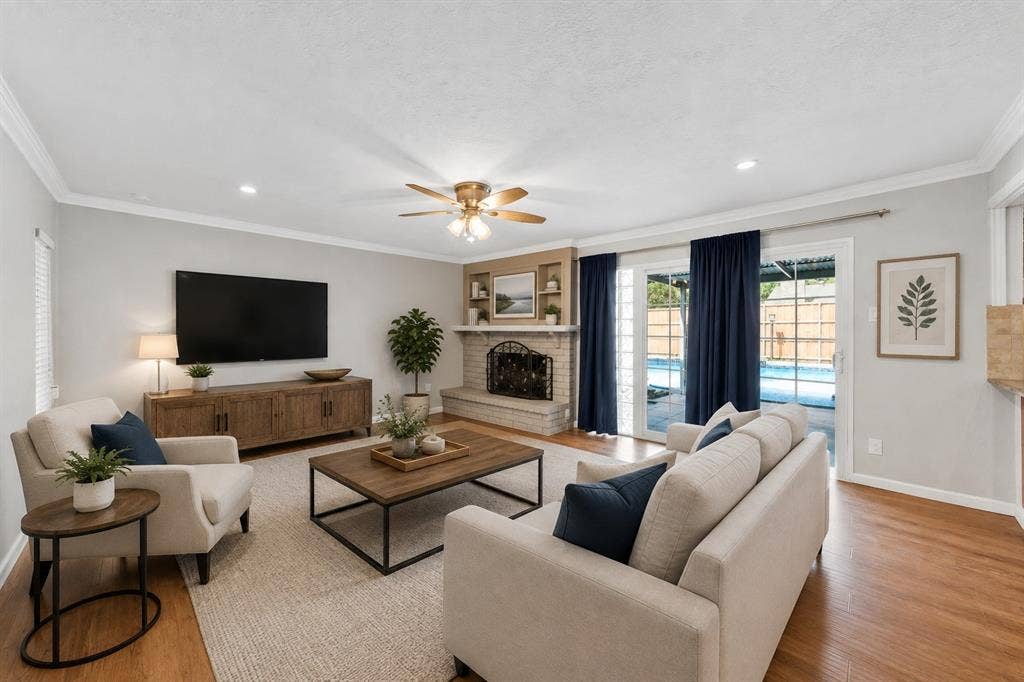 1715 Cherokee Trail, Plano, TX 75023 Hardwood flooring, crown molding, brick fireplace with mantel, ceiling fan, and sliding glass doors with direct outdoor access