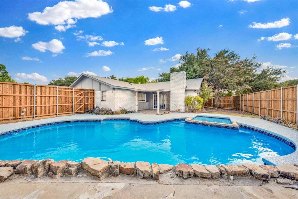 1715 Cherokee Trail, Plano, TX 75023 Exterior featuring a fenced backyard, swimming pool, and raised spa