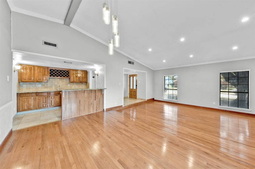 1715 Cherokee Trail, Plano, TX 75023 Vaulted ceiling with pendant lighting, recessed lighting, wood-finish flooring, wood cabinetry, and a built-in wet bar