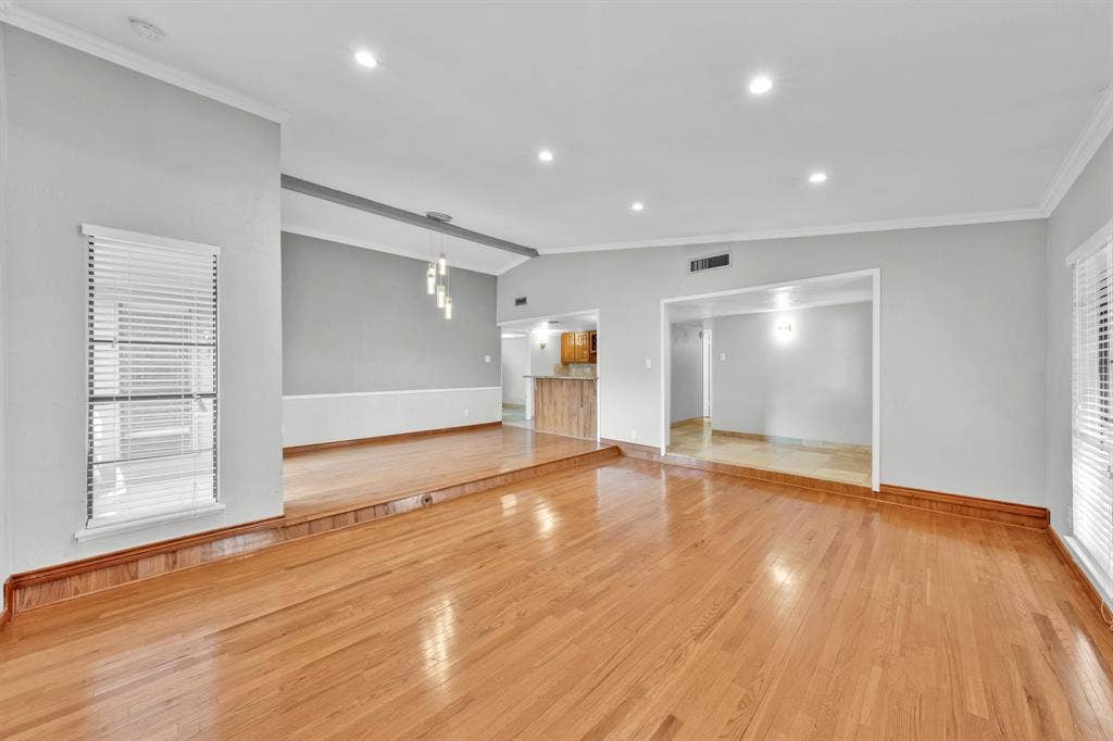 1715 Cherokee Trail, Plano, TX 75023 Hardwood flooring throughout, recessed ceiling lighting, light-toned walls, decorative ceiling light fixture, and arched doorway