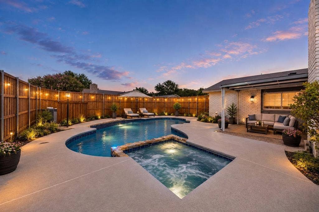1715 Cherokee Trail, Plano, TX 75023 In-ground swimming pool with integrated spa, concrete patio, covered outdoor living area, and wood privacy fencing