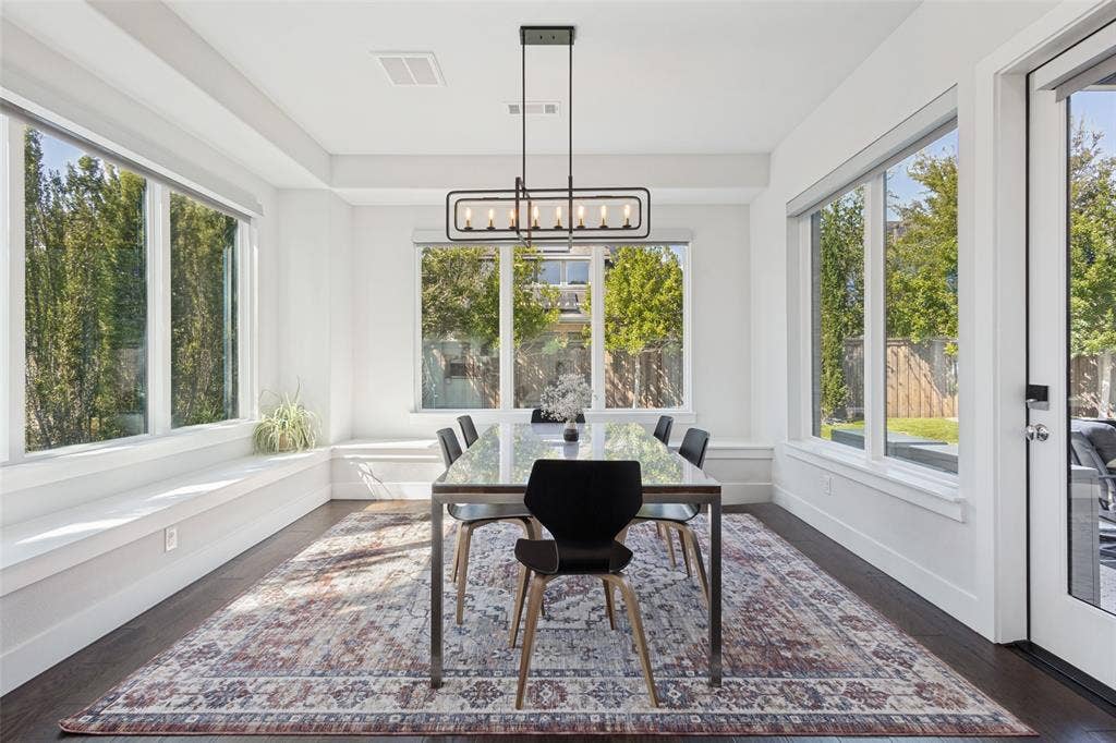 15018 Crape Myrtle Road, Frisco, TX 75035 Window-lined dining area with dark wood-finish flooring, a contemporary chandelier, and a built-in window bench