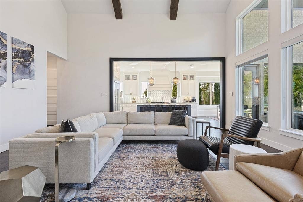 15018 Crape Myrtle Road, Frisco, TX 75035 Vaulted ceilings with exposed beams, dark wood-finish flooring, and expansive windows