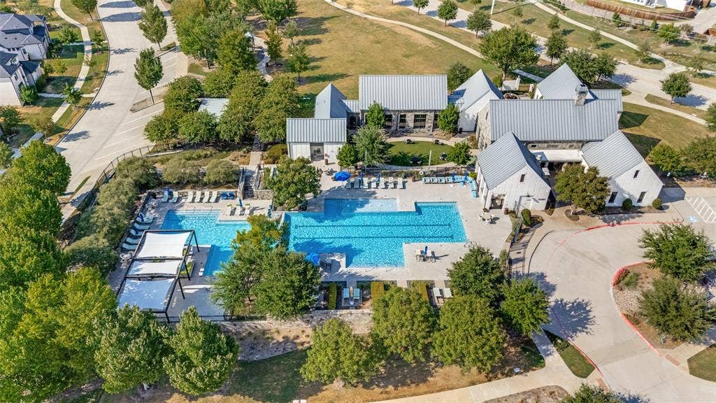 15018 Crape Myrtle Road, Frisco, TX 75035 Expansive outdoor pool with multiple lounging areas, shaded pergolas, and adjacent recreational building with stone and siding exterior