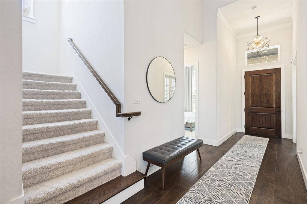 15018 Crape Myrtle Road, Frisco, TX 75035 Entryway with a dark wood-paneled door, transom window, and a geometric pendant light fixture