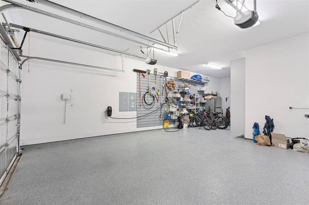 15018 Crape Myrtle Road, Frisco, TX 75035 Spacious garage featuring a durable epoxy floor, integrated overhead lighting, and an electric vehicle charging station