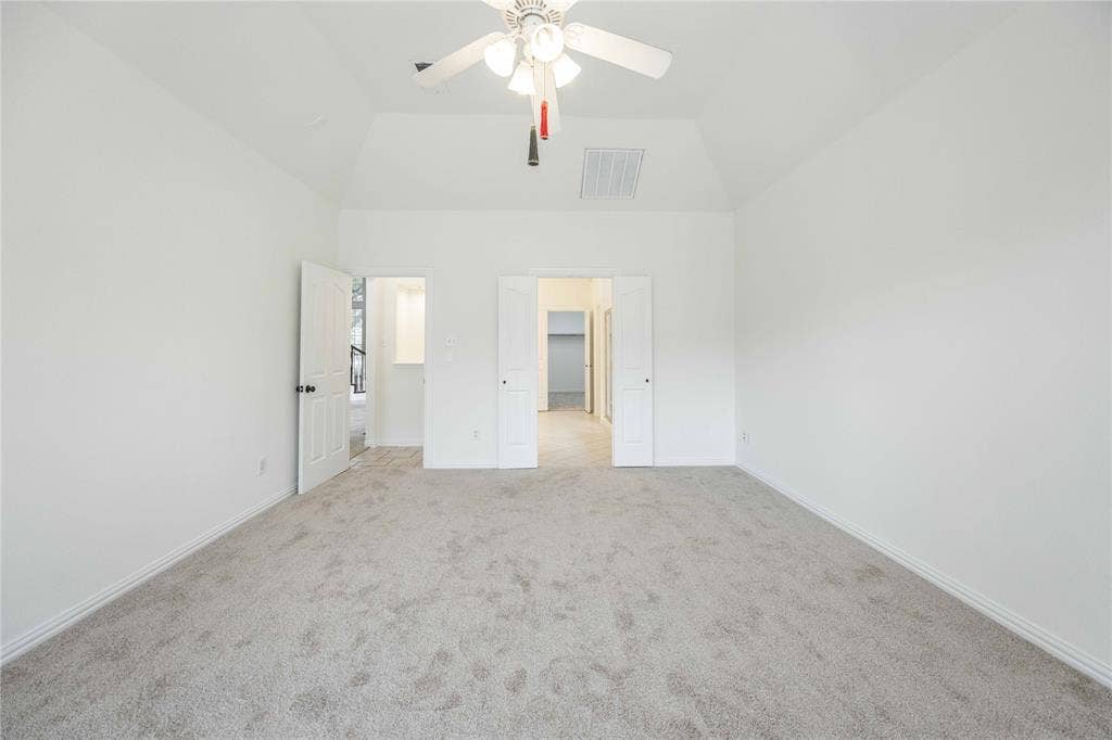 3305 Estacado Lane, Plano, TX 75025 Vaulted ceiling, light-toned carpet, white walls, ceiling fan with light fixture, and white interior doors