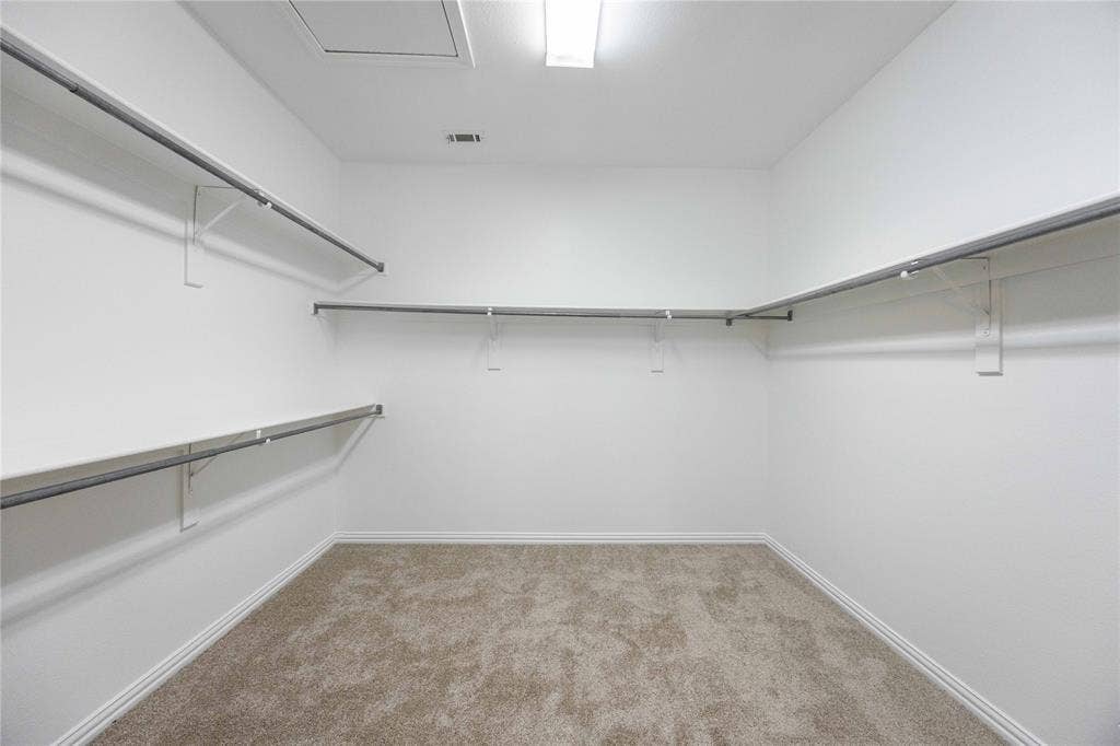 3305 Estacado Lane, Plano, TX 75025 Spacious closet featuring wall-mounted garment rods, light-toned carpet, and white trim